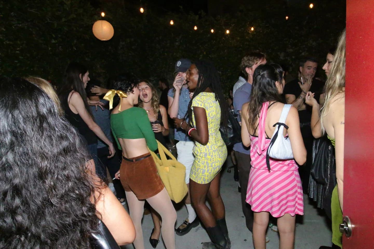 Guests talking beneath string lights at a magazine event