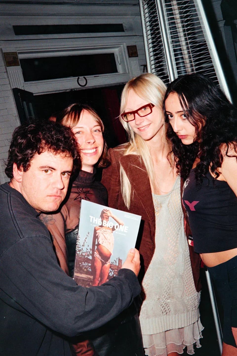 Guests holding a magazine and posing together