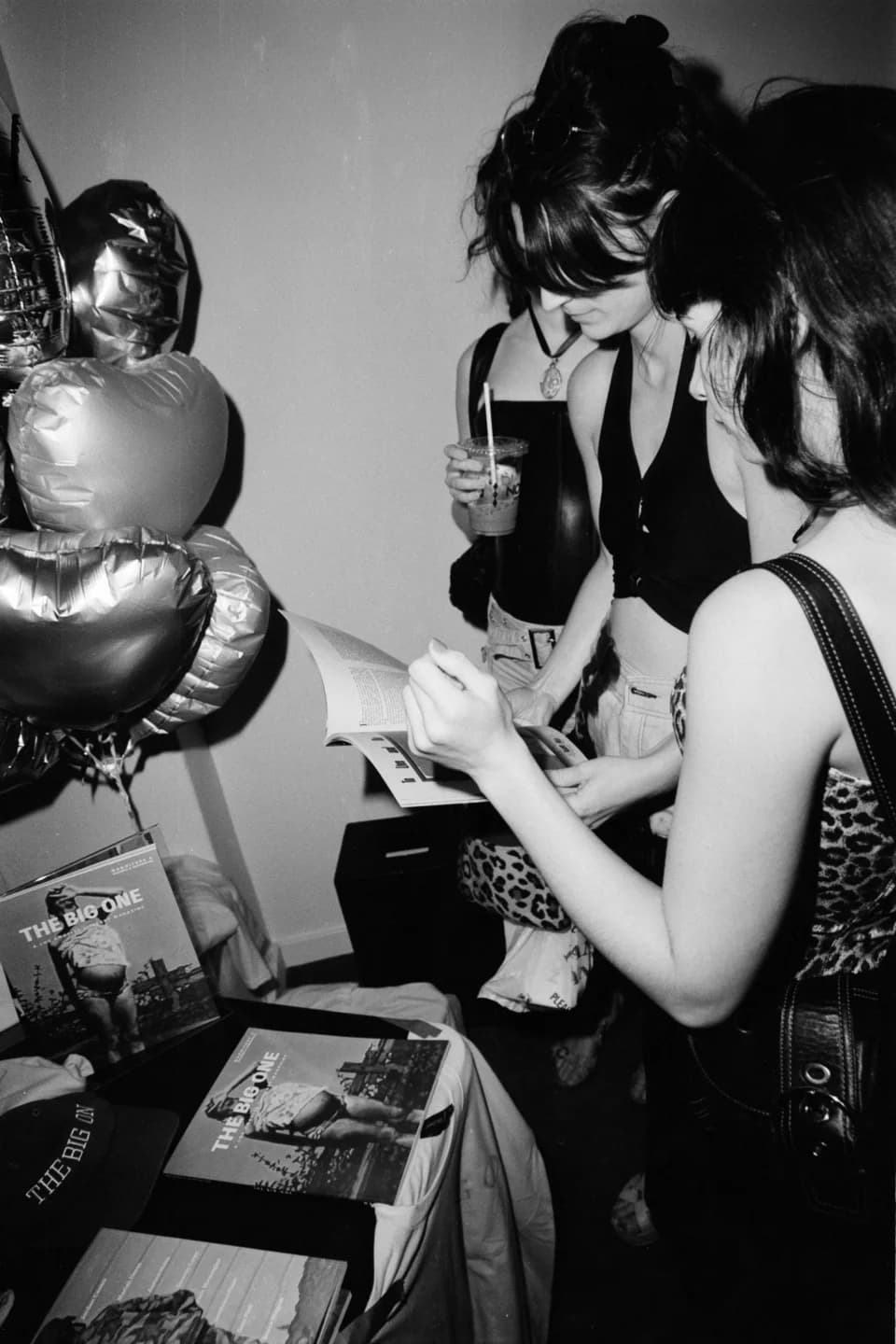 Guests browsing the magazine table, in black and white