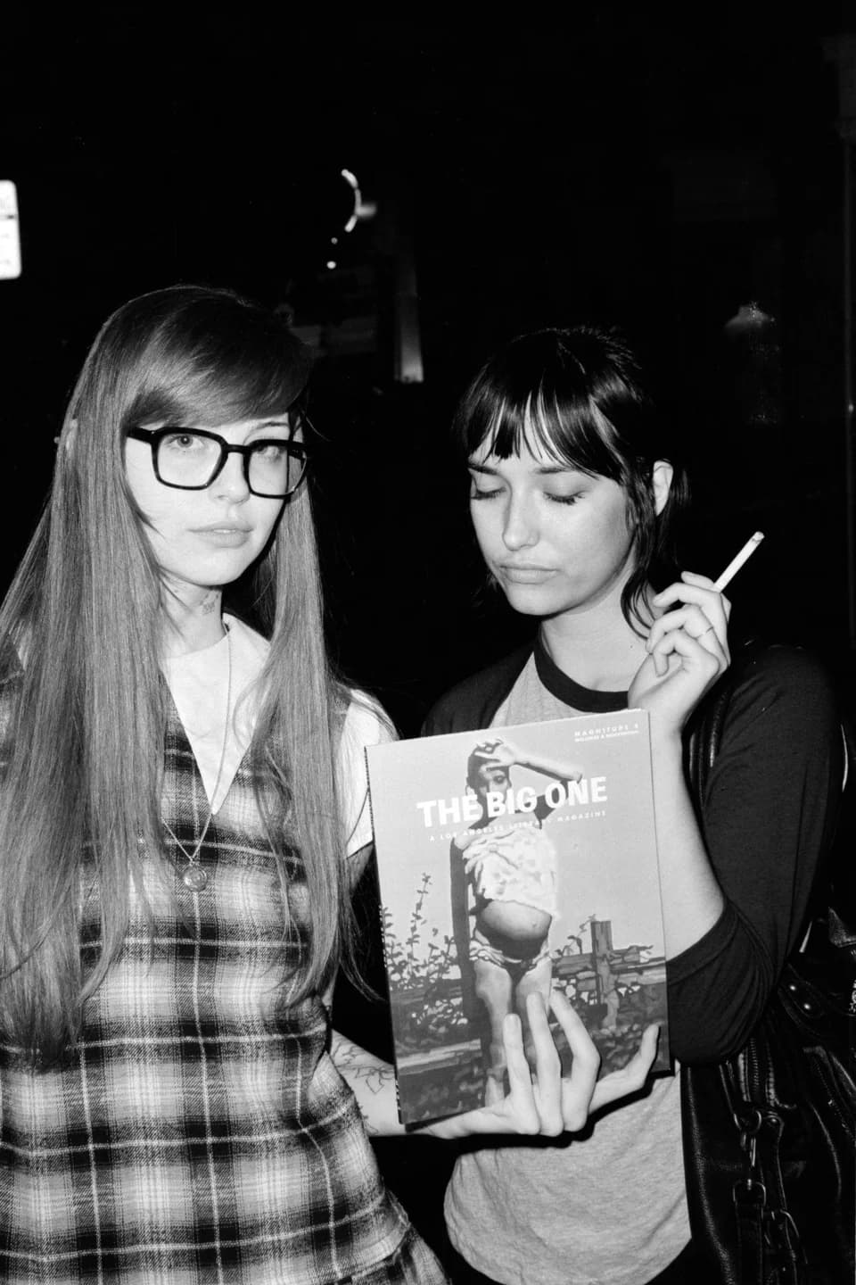 Two guests holding up The Big One, in black and white