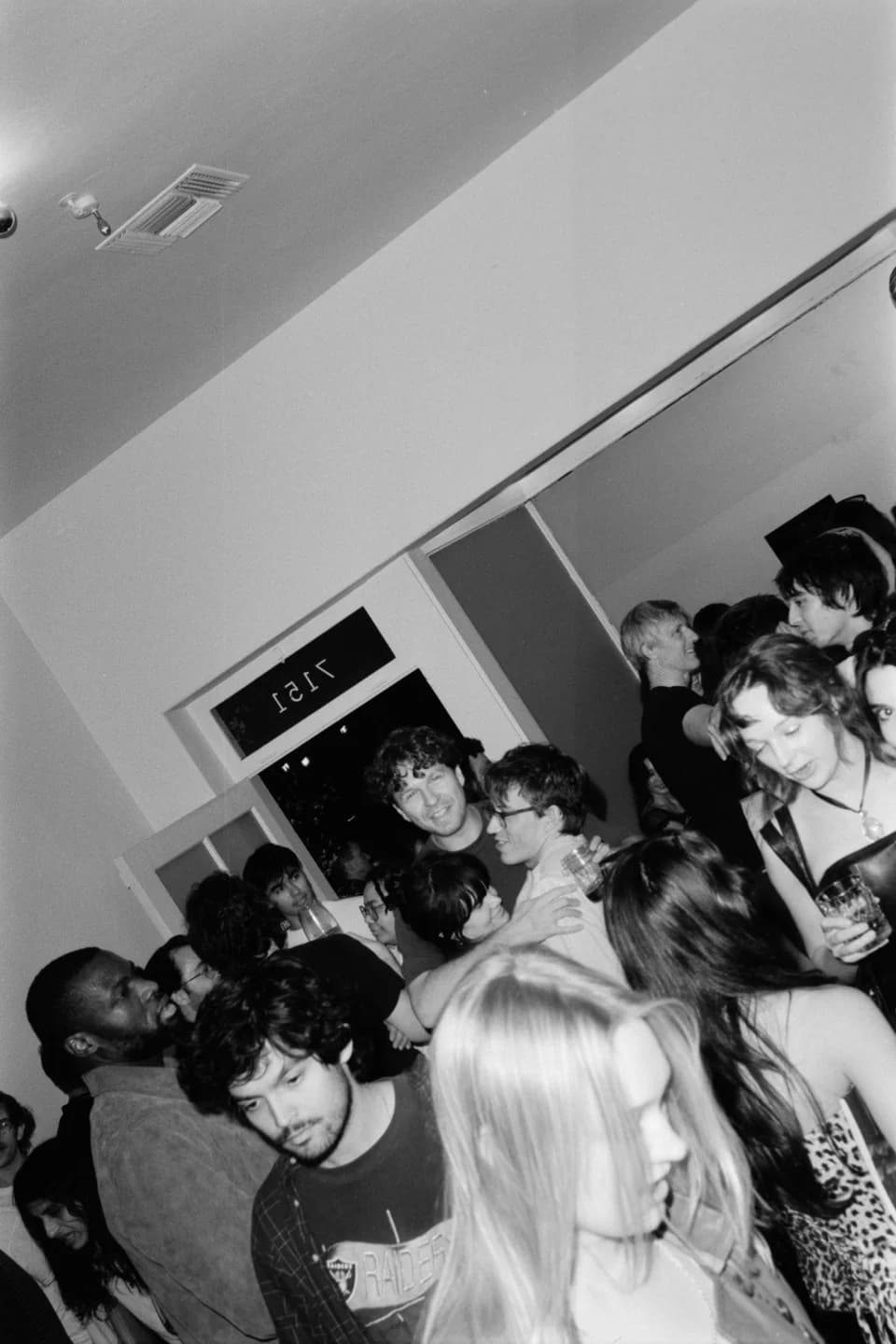 Guests filling an indoor event space, in black and white