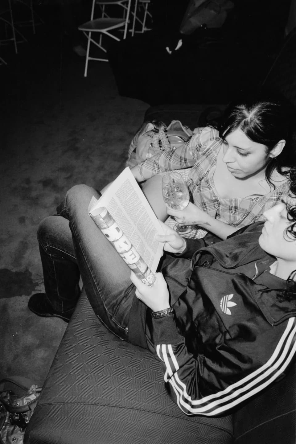 Guests reading a magazine together, in black and white